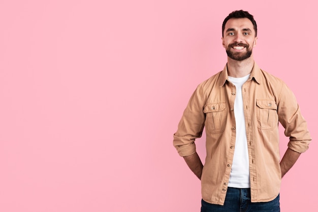 Foto gratuita uomo di smiley che propone con lo spazio della copia