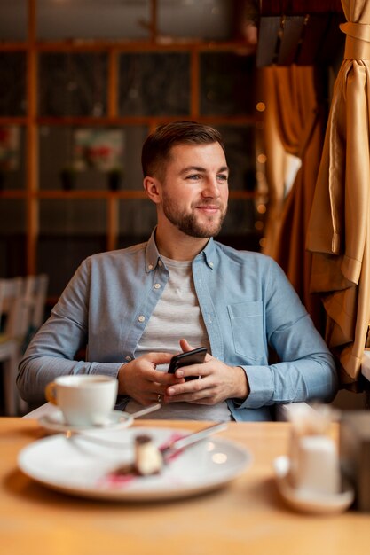 smiley man at restaurant with phone