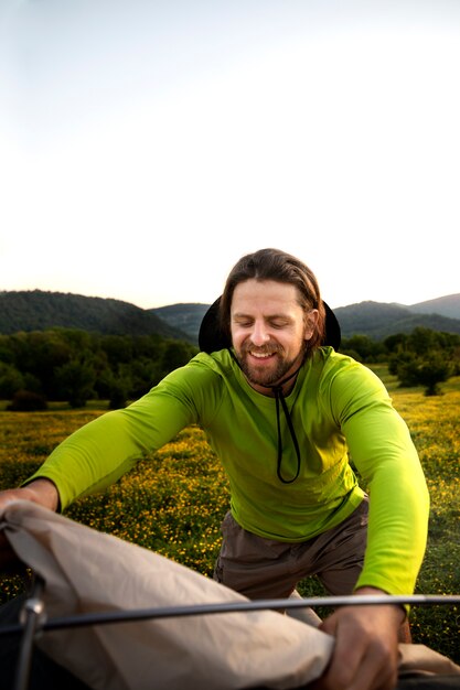 Smiley  man setting up tent medium shot