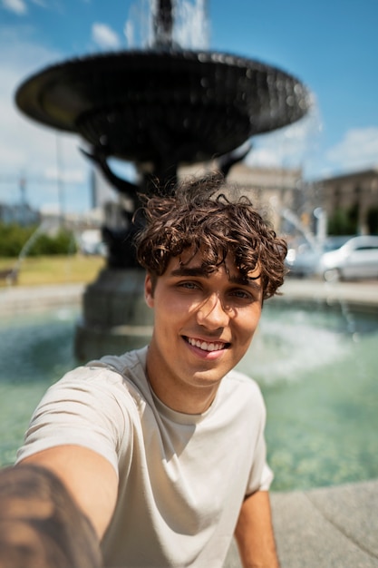 Smiley man taking selfie outdoors medium shot