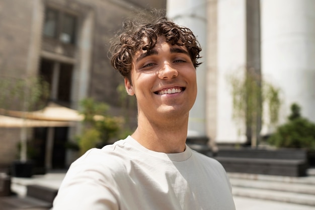 smiley man taking selfie outside medium shot
