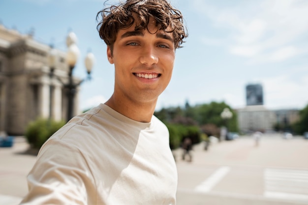 Smiley man taking selfie outside side view