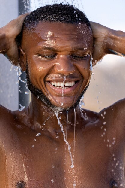 Smiley man taking shower portrait front view