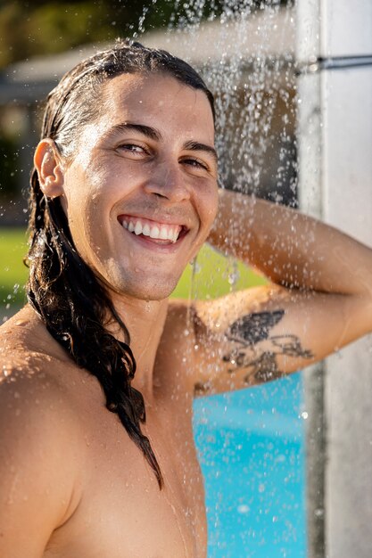 Uomo sorridente che prende la vista laterale della doccia