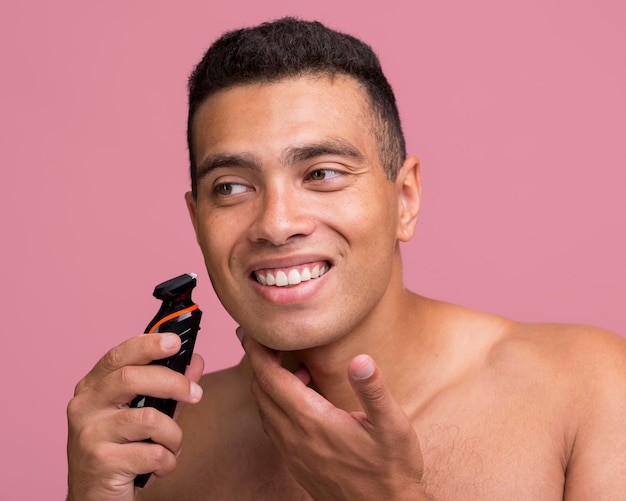 Smiley man using an electric shaver