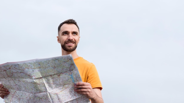 Smiley man using a map low view