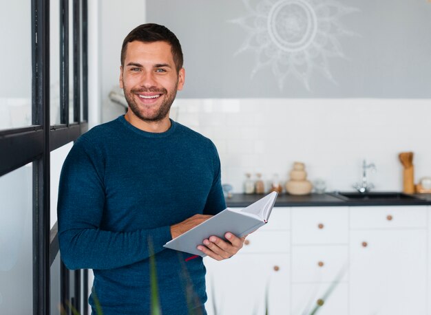 Smiley man with book looking at camera