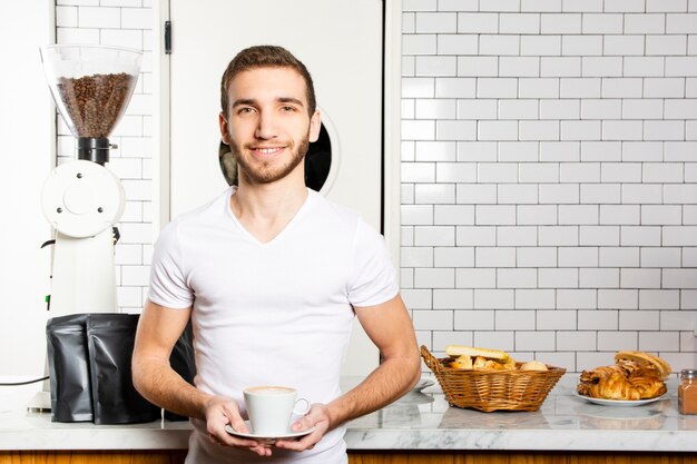 Smiley man with a cup of cappuccino in his hands