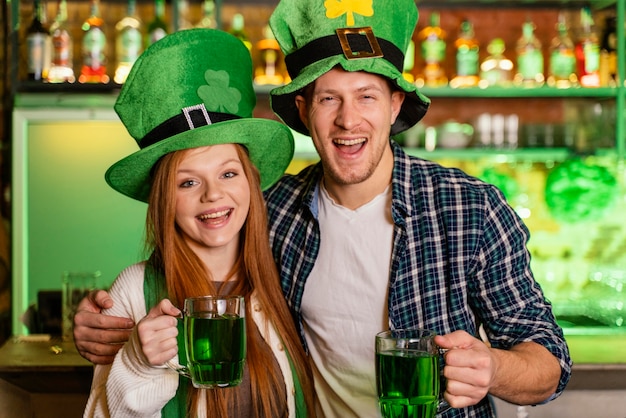 Smiley man and woman celebrating st. patrick's day at the bar