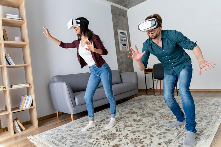 मुफ़्त फोटो smiley man and woman having fun at home with virtual reality headset