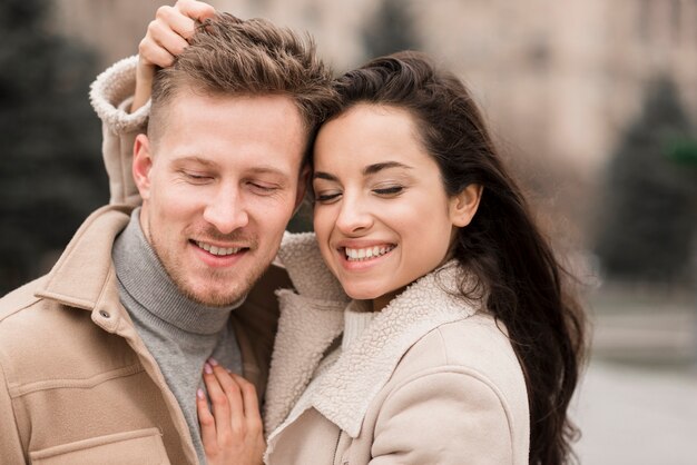 Smiley man and woman posing outdoors