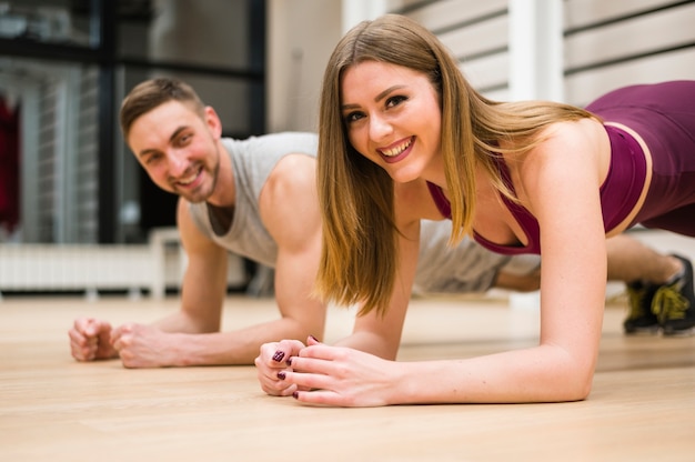 Smiley man and woman working out