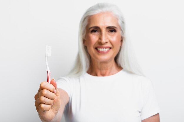 Smiley mature woman proud of her toothbrush