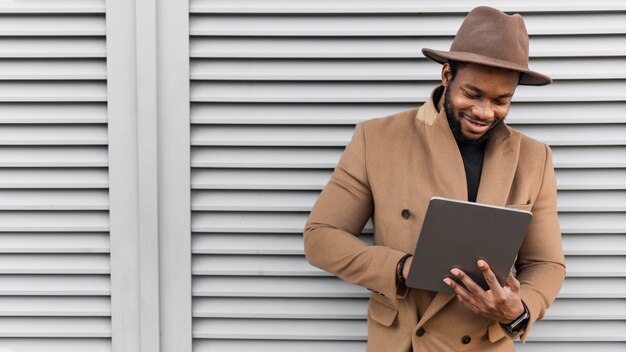 Smiley modern man looking on his tablet