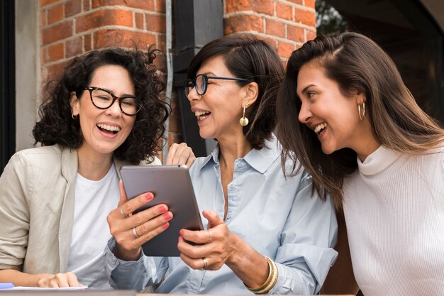 Smiley modern women looking on a tablet