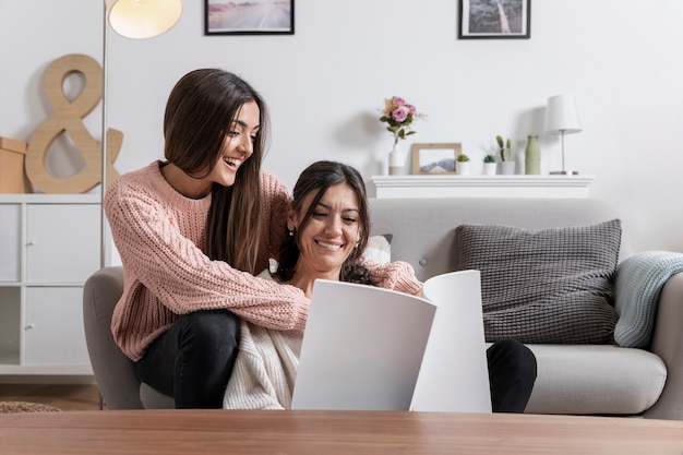 Smiley mom and girl at home reading