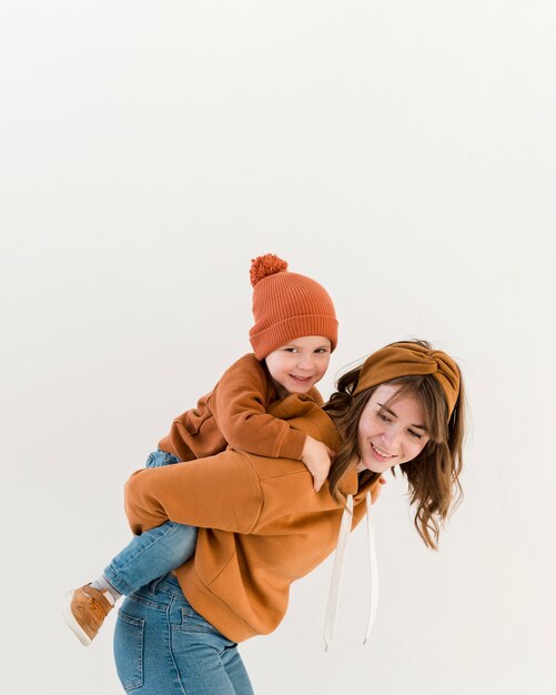 smiley mom with son in piggy back ride