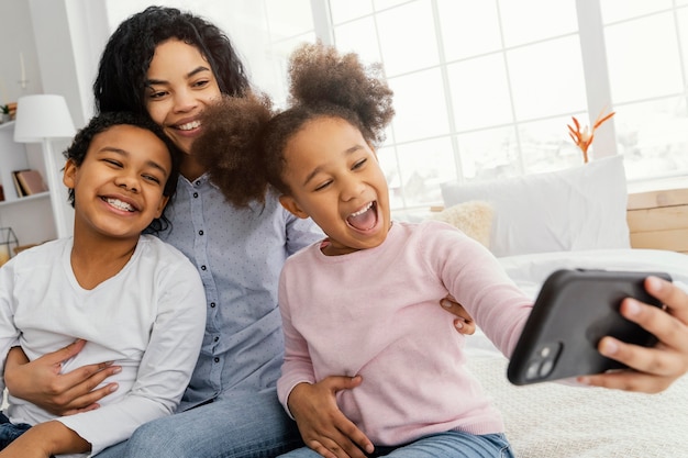 Smiley mother and children taking selfie at home