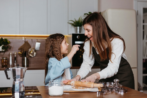 Smiley mother and daughter cooking together in the kitchen