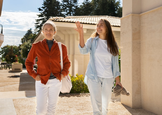 Faccina sorridente madre e figlia che camminano vista frontale