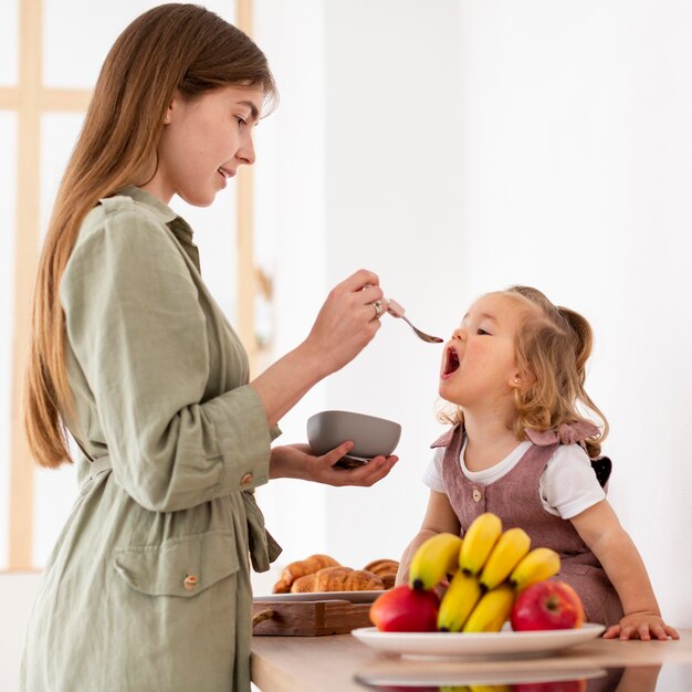 Smiley mother feeding daughter