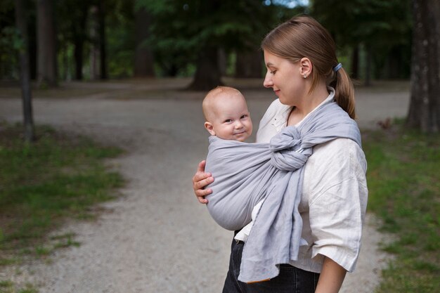 Smiley mother holding baby side view