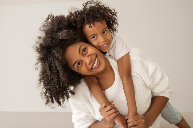 Smiley mother holding kid front view