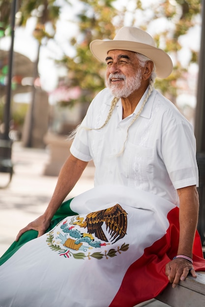 Free photo smiley old man with mexican flag side view