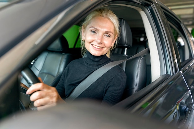 Free photo smiley older business woman driving car