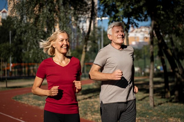 Smiley older couple jogging outdoors