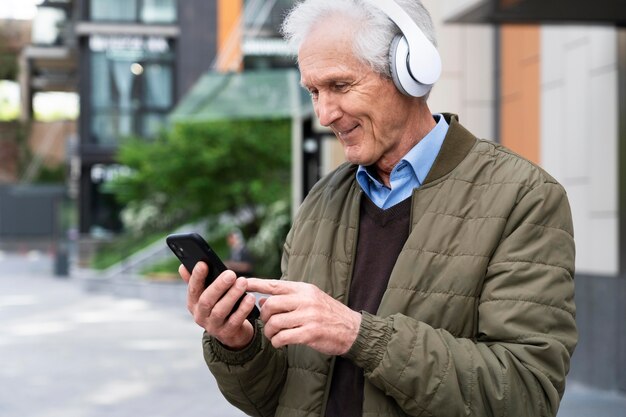 Смайлик пожилой мужчина в городе, слушающий музыку в наушниках