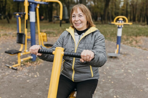 屋外で運動するスマイリー年上の女性