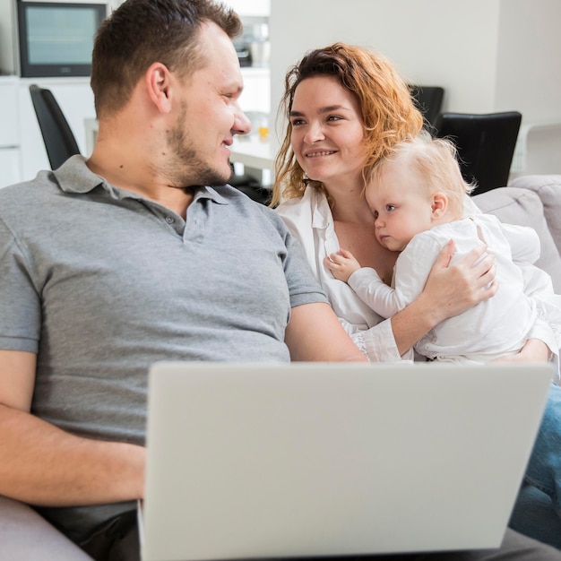 Smiley parents holding baby