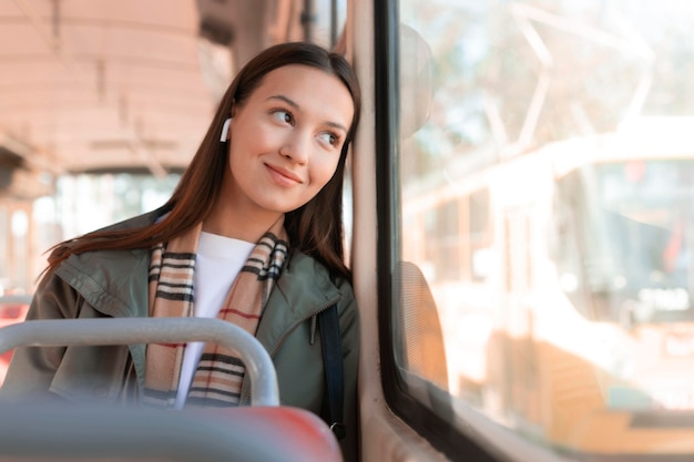 Бесплатное фото Улыбающийся пассажир смотрит в окно трамвая