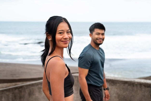 Foto gratuita persone sorridenti alla vista laterale della spiaggia