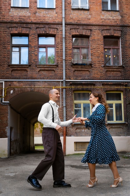 Smiley people dancing outdoors full shot