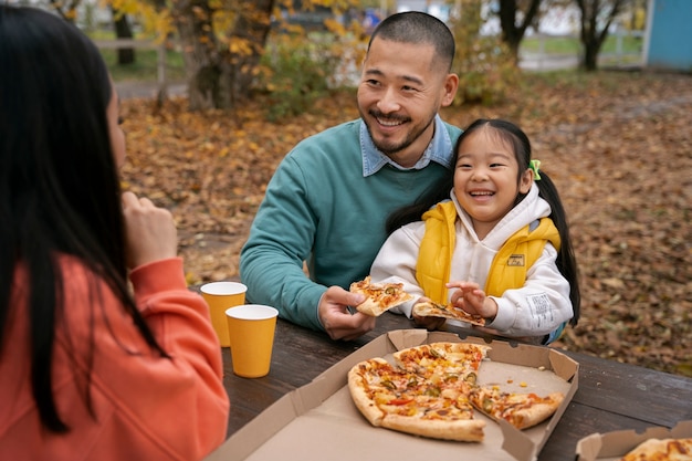 ピザの側面図を食べるスマイリーの人々