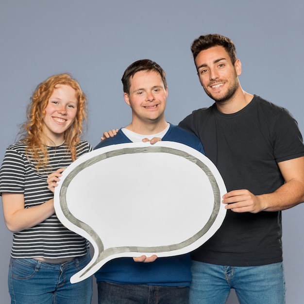 Free photo smiley people holding a paper speech bubble