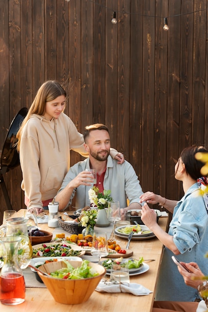 Foto gratuita persone sorridenti sedute a tavola