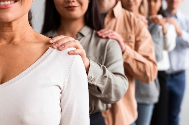 Foto gratuita persone di smiley toccando le spalle in una sessione di terapia di gruppo