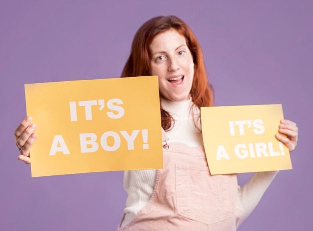 Smiley pregnant female holding paper with baby gender