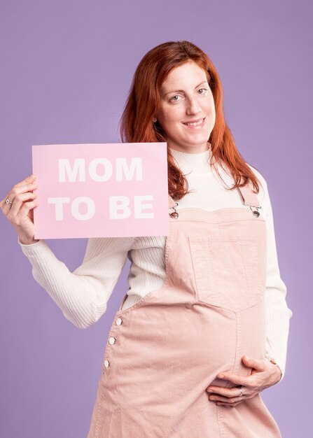 Смайлик беременная женщина, держащая бумагу с мамой, чтобы быть сообщением