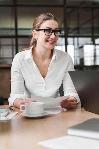 Foto gratuita smiley imprenditrice professionale con gli occhiali durante una riunione