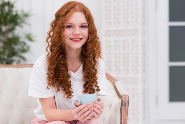 Smiley red hair woman drinking tea