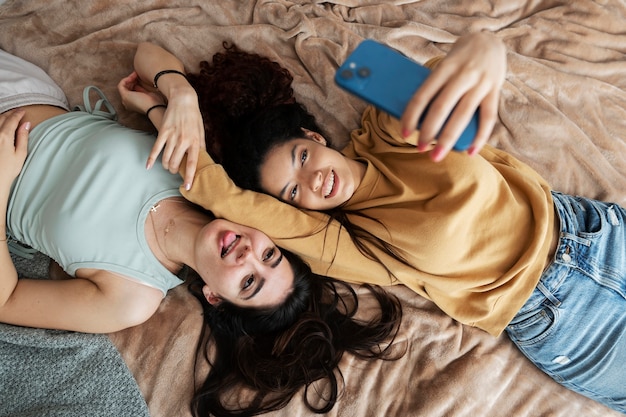 Compagni di stanza sorridenti che prendono selfie vista dall'alto