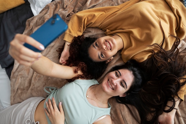 Free photo smiley roommates taking selfie above view