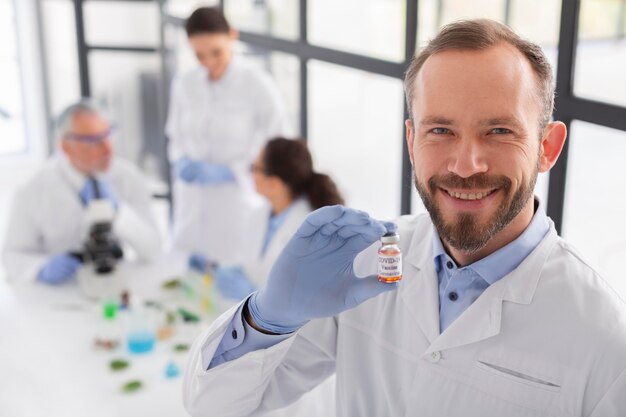 Smiley scientist holding vial