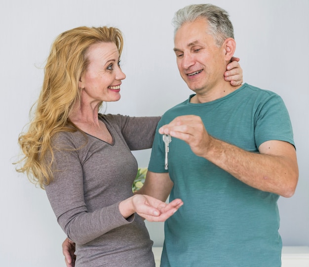 Free photo smiley senior couple exchanging key