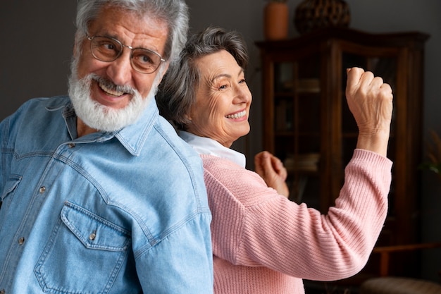 Free photo smiley senior couple indoors side view