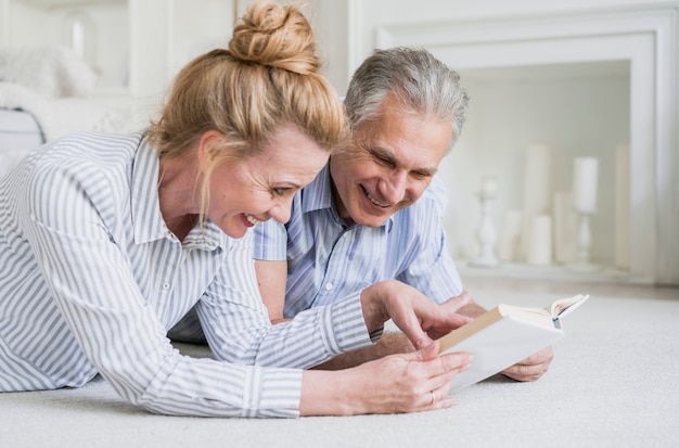 Smiley senior couple with a book 